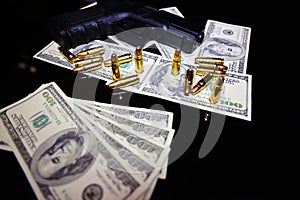 Gun and bullets on dollar banknotes background