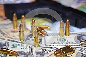 Gun and bullets on dollar and euro banknotes background