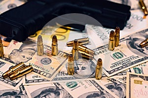 Gun and bullets on dollar and euro banknotes background