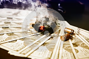 Gun with bullets lying on the table. Money on black background. Criminal problems. Dollars