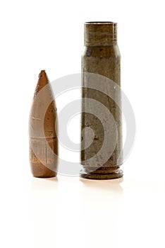 Gun cartridge with bullet and case on white background with reflexion