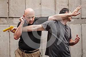 Gun Disarm. Self defense techniques against a gun point. photo