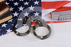 Gun and handcuffs on an American flag law enforcement in the USA