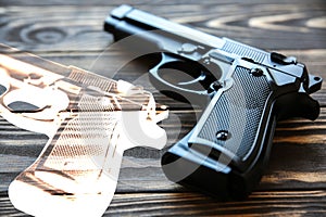 Gun lying on wooden background. Legalization of weapon