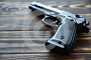 Gun lying on wooden background. Legalization of weapon photo