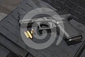 gun and 9mm bullets on a bulletproof jacket