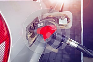 Gun for refueling in tank of car at gas station. car is at gas station close-up. fuel gas tank car with pistol and filling hose.