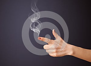 Gun shaped woman hand with smoke