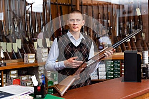 Gun shop salesman showing double barreled hunting rifle