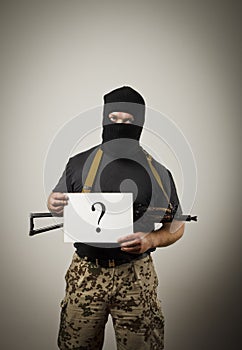 Gunman holding white paper with question-mark.