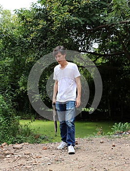 The gunner man holding long gun in hand with white shirt and denim jean.