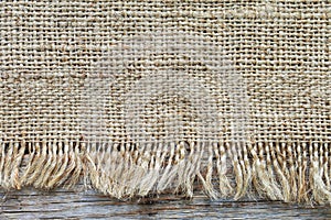 Gunny sack texture and wooden plank background.