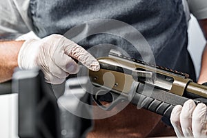 The gunsmith maintaining his rifle in a workshop photo