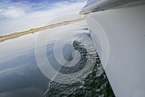 Gunwale view of sailboat sailing across Alange Reservoir, Spain