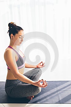 Guptasana. Beautiful yoga woman practice in a traning hall background. photo