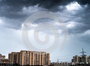 Gurgaon delhi cityscape with monsoon clouds casting shadows on high rise apartments and buildings showing passage of