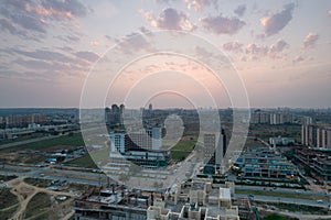 aerial dusk shot showing 3 roads mall in gurgaon with lights switched on and traffic moving on the busy road in front photo