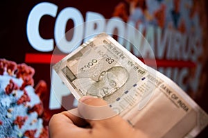 Indian money note with coronavirus written behind it photo