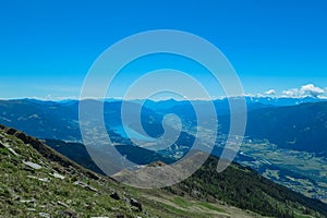 Gurglitzen - Idyllic hiking trail on alpine meadow with scenic view of lake Millstatt seen from mountain peak Boese Nase