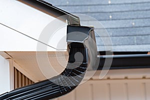 gutter with downpipe on the roof of a house