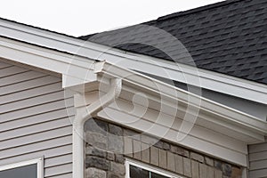 gutter with downpipe on the roof of a house