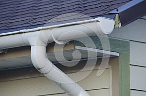 Gutter on the roof of the house. White color.