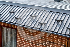 . Gutter system for a metal roof. Holder gutter drainage system on the roof