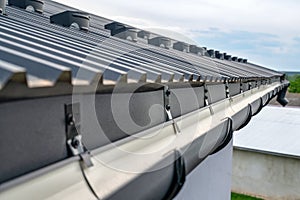 . Gutter system for a metal roof. Holder gutter drainage system on the roof