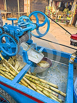 Guwahati, India - March 19, 2020: Street side sugarcane juice maker, making the juice by crashing the sugercanes.