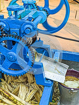 Guwahati, India - March 19, 2020: Street side sugarcane juice maker, making the juice by crashing the sugercanes.