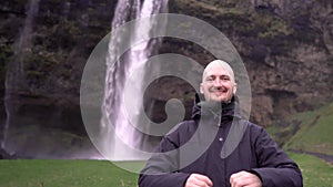 Guy against the backdrop of a waterfall in Iceland