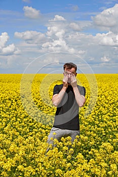 a guy with allergies to plants and pollen rubs his eyes and nose