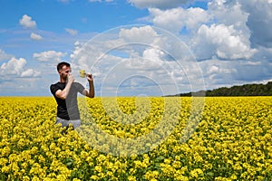 a guy with an allergy to pollen in a rapeseed field closes his nose