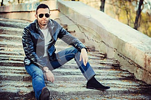 guy with attitude wearing leather jacket and sunglasses out