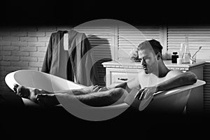 Guy in bathroom holding book and looking suspicious photo