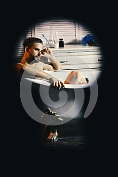 Guy in bathroom with toiletries on background. Sex and relaxation concept. Man with beard and dreamy face. Macho sitting