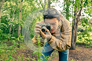 Guy biologist in glasses photographs plants