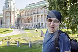 A guy in a black bandana and sunglasses says welcome, inviting you to visit historical palace
