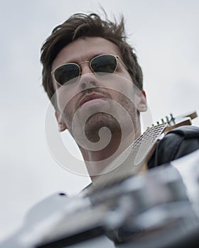 a guy in black glasses with a guitar. Musical art, rock festival