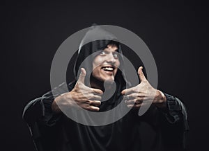 Guy in a black robe showing thumbs up