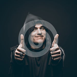 Guy in a black robe showing thumbs up