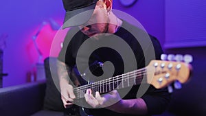 Guy in black shirt plays the electric guitar. Rock star plays. Close up view of the fingers on guitar riff