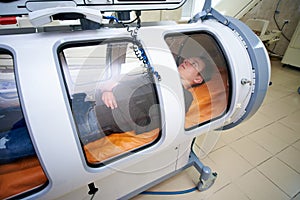The guy in the black T-shirt lies in the hyperbaric chamber, oxygen therapy