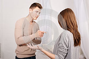 The guy blames the girl in something, the girl innocently spreads her hands to. Indoors.