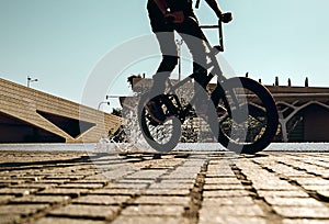 Guy with a bmx doing tricks for the city.