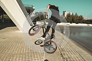 Guy with a bmx doing tricks for the city. Concept of young people doing extreme sports