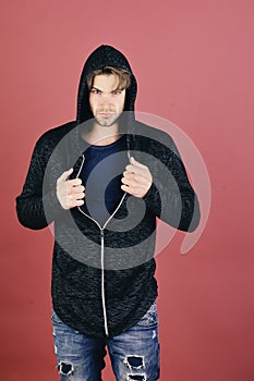 Guy with bristle in dark blue tshirt and grey hoodie.