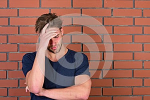 Guy with bristle in dark blue tshirt suffers from headache