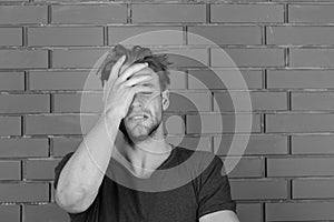 Guy with bristle in dark blue tshirt suffers from headache