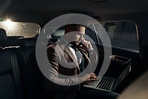 Guy in car with laptop and phone